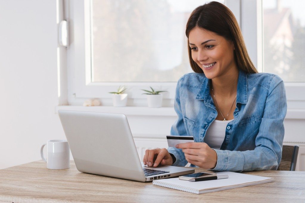 Woman holding credit card purchasing online