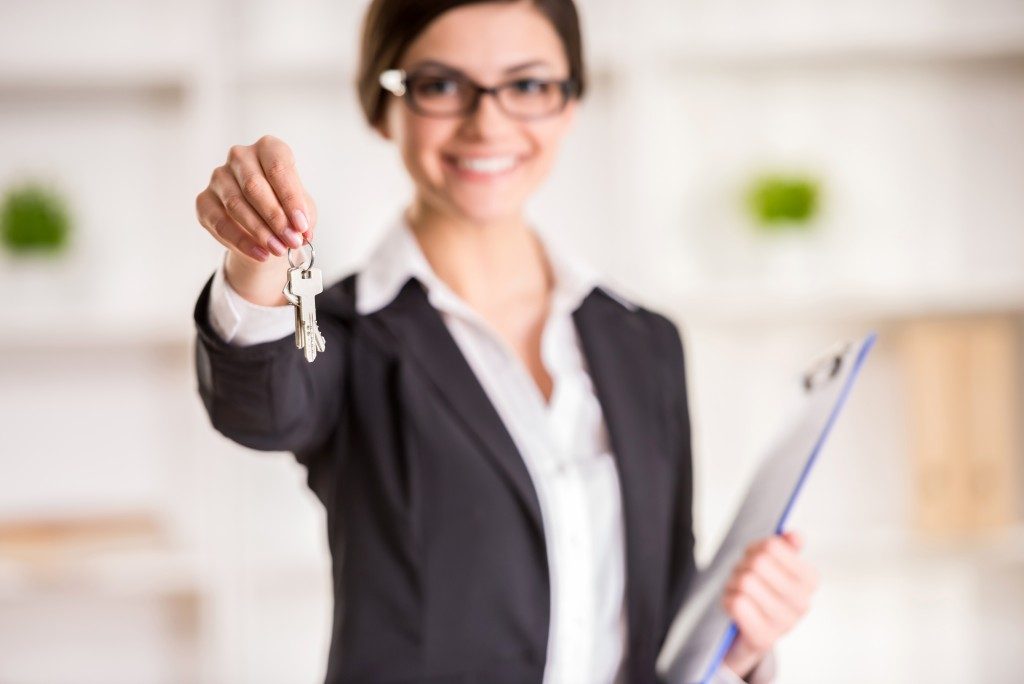 woman is holding the keys to an apartment to clients