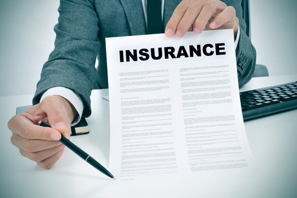 Man in suit showing an insurance policy while holding a pen