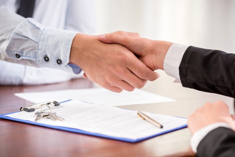 client and broker shaking hands over a property being bought
