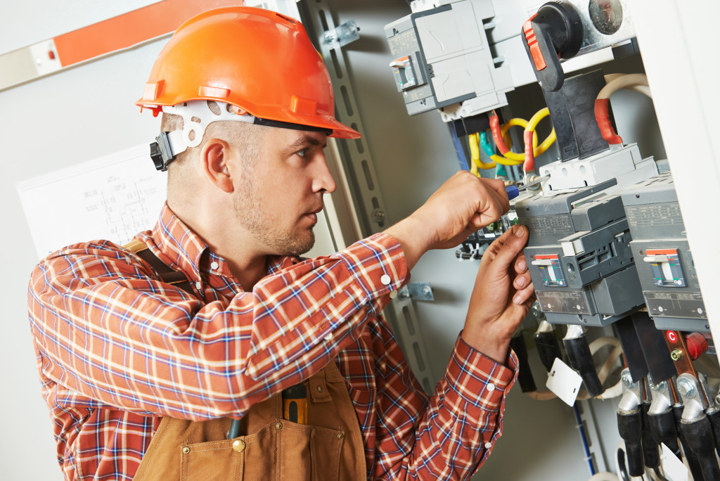 An electrician fixing electrical wiring in a fuse box