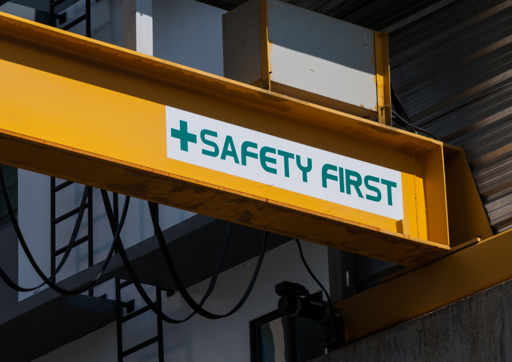safety first sign on a yellow metal