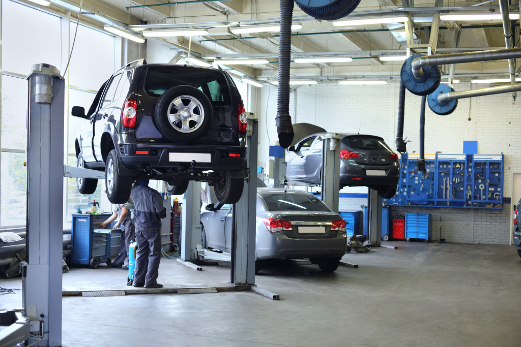 Cars being repaired in an auto shop, using lifts