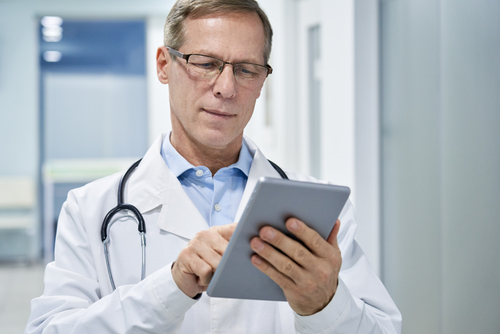 a doctor using tablet for patients' records